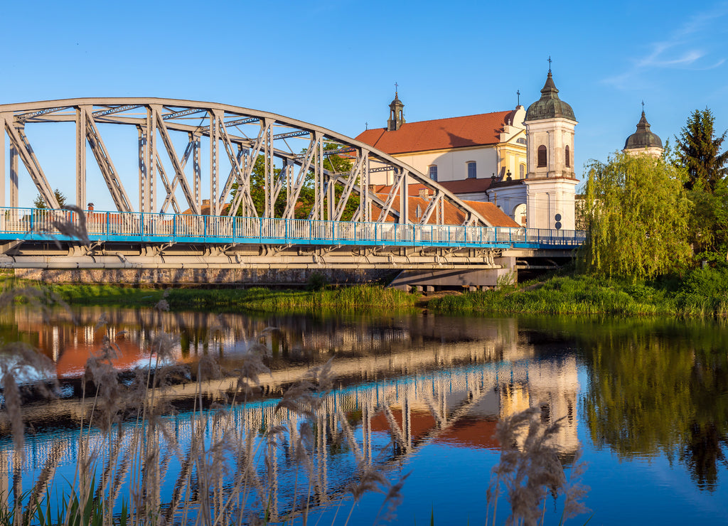 View at bridge over the Narew river and baroque Church in Tykocin town, Podlasie, Poland
