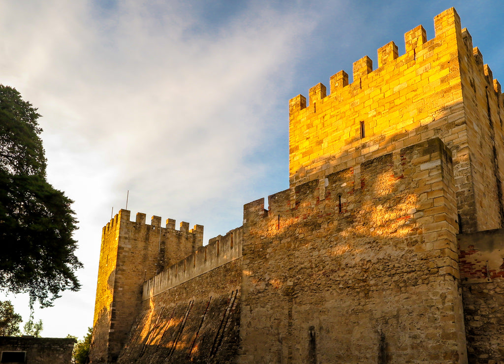 São Jorge Castle under the sunset sun, blue sky with clouds, Lisbon, Portugal