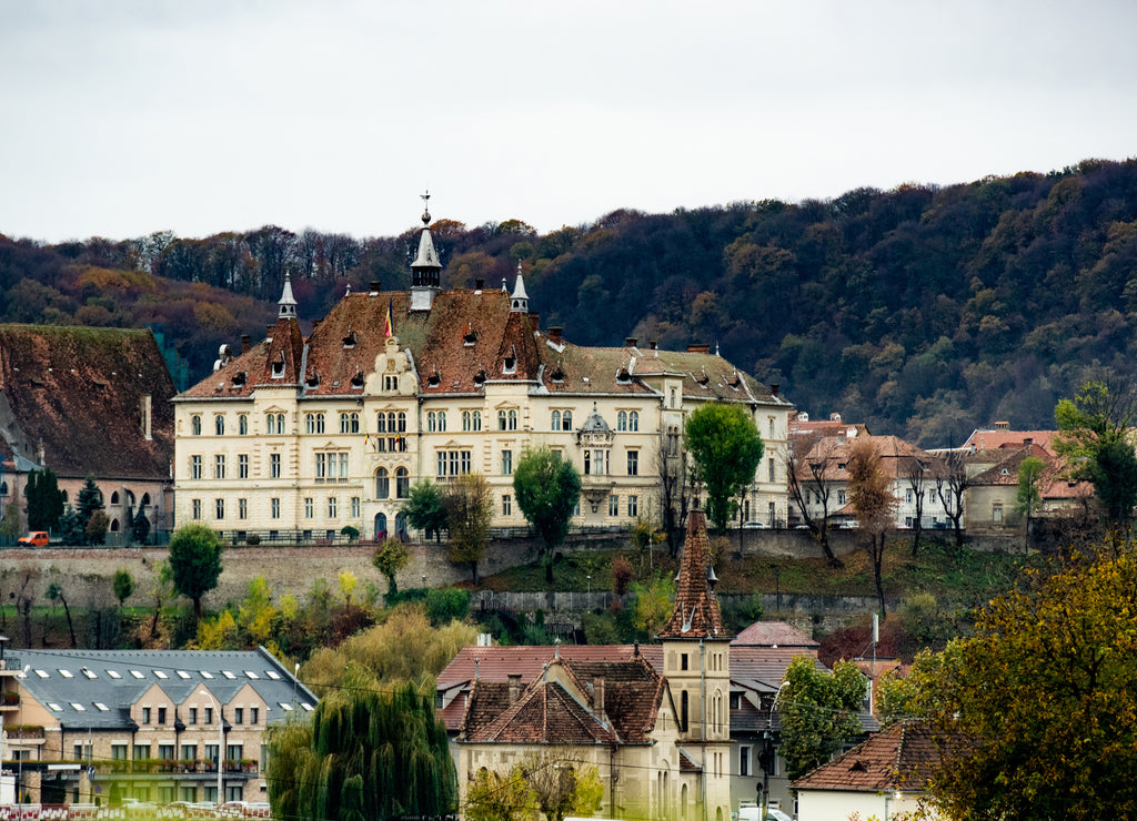 Ancient Sighisoara city in Romania, panoramic old clock tower, castle and medieval architecture view. Historic european town with Dracula house