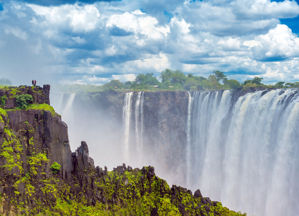 Panorama view with dramatic clouds and waterfall at Victoria Falls on the Zambezi River, Zimbabwe, Zambia