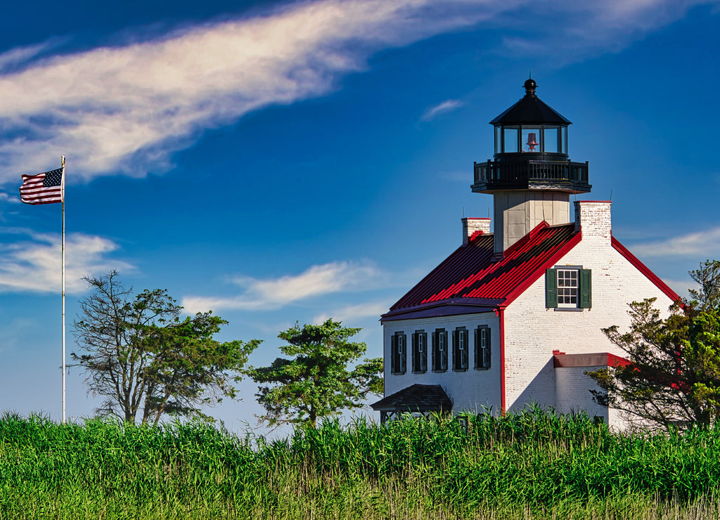 The East Point Lighthouse with a waving American Flag in Maurice River County, New Jersey