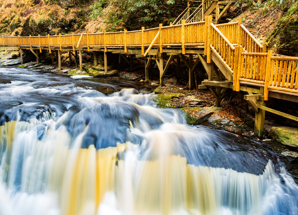 Waterfall on Little Bushkill creek. Wooden footpath borders the river. Little Bushkill Creek is a tributary of the Delaware River in eastern Pennsylvania