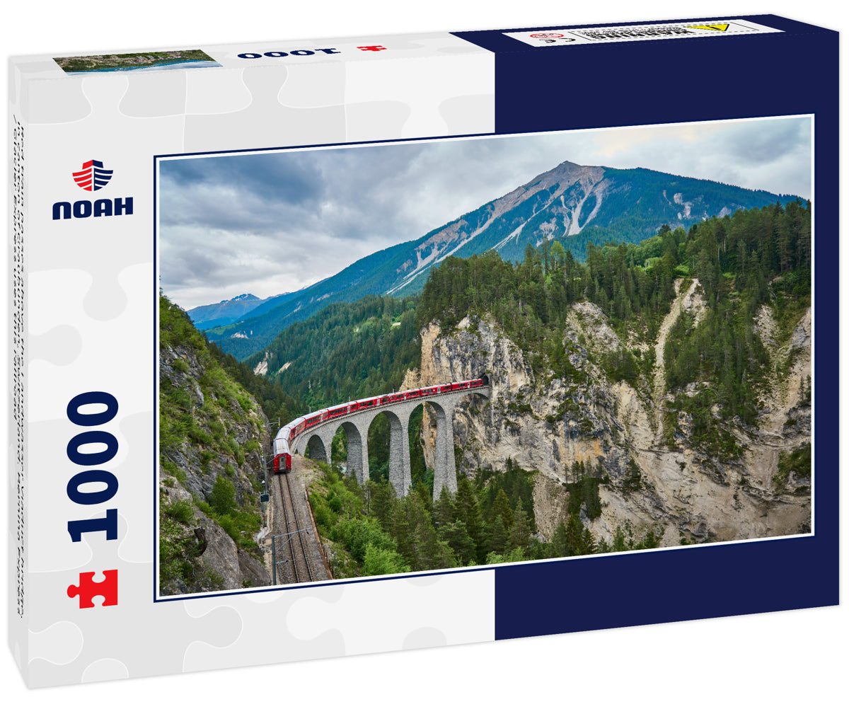 Red train passes above the Landwasser Viaduct bridge, in canton of Graubünden, Switzerland. Bernina Express / Glacier Express uses this railroad