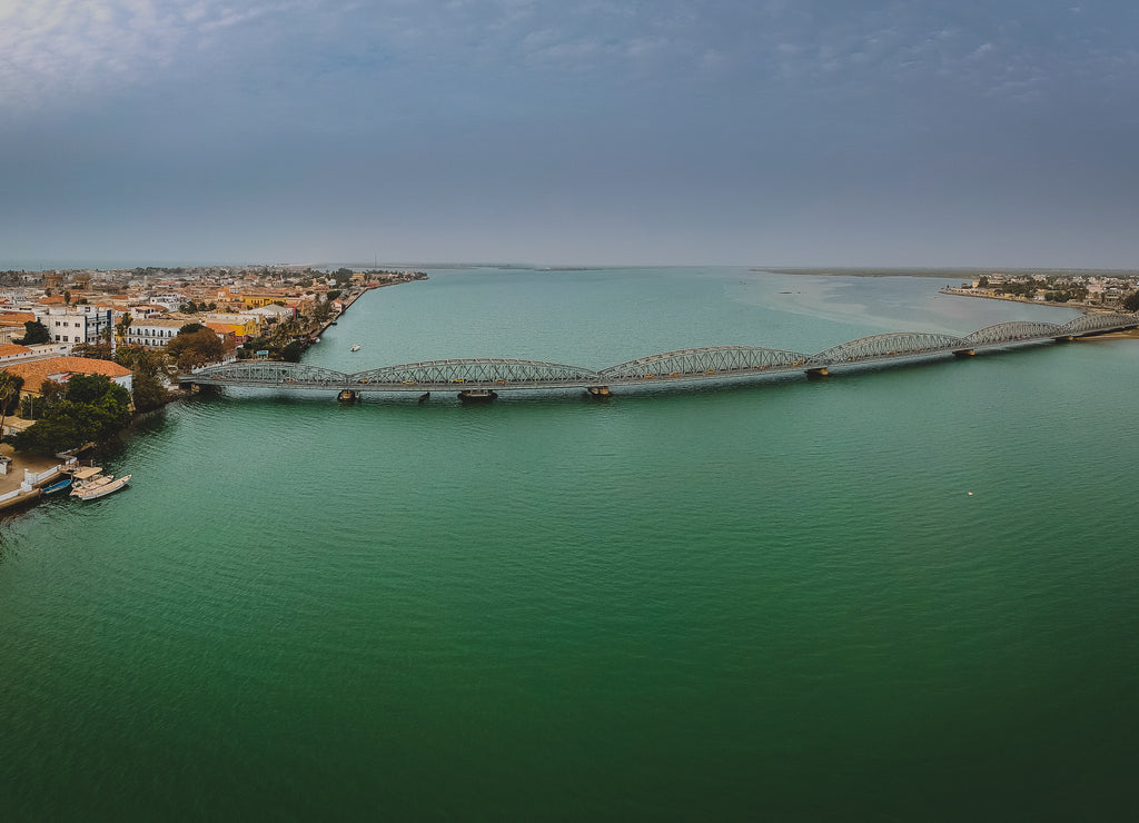 Aerial photo of Senegal river in Sant Louis, Senegal, with the Faidherbe bridge seen connecting the new part of the city on an overcast day
