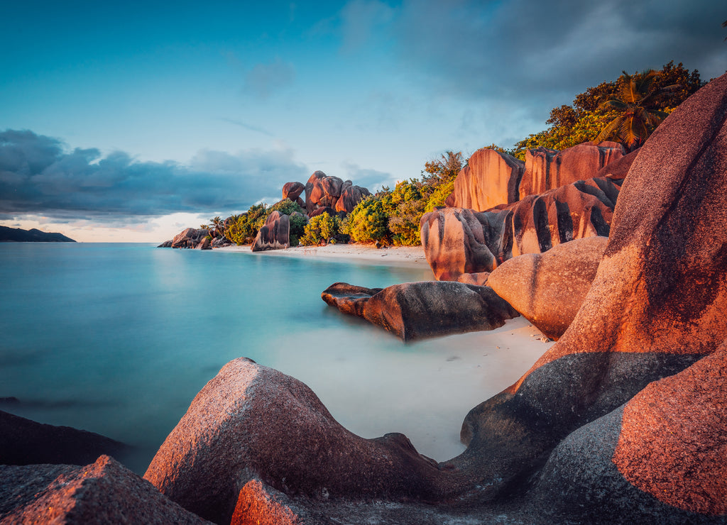 Unique shaped granite boulders and a dramatic sunset at Anse Source d'Argent beach, La Digue island, Seychelles. Long Exposure