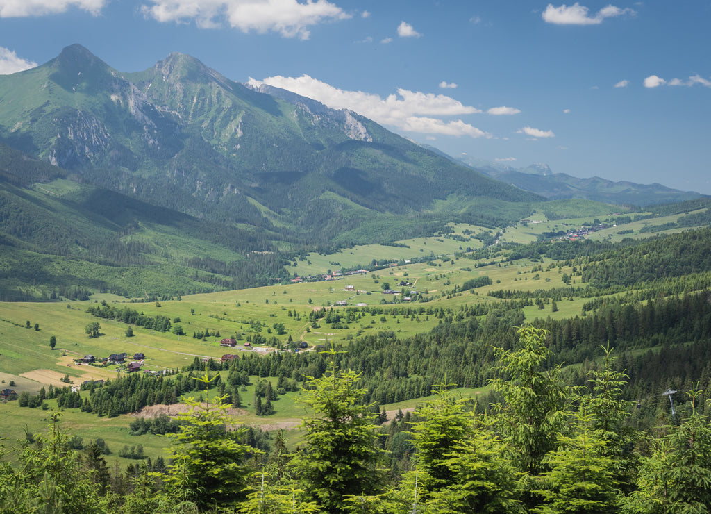 Beautiful elevated view of mountains in Slovakia. Bachledova dolina, Zdiar village and Belianske Tatry mountains seen from an elevated viewpoint on a hiking trail on summer day