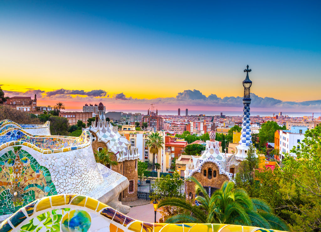View of mosaic tile and Barcelona cityscape in park Guell at sunset | Spain