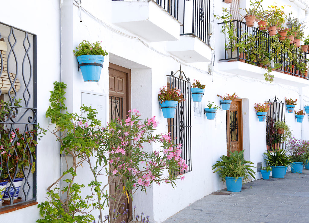 Picturesque street of Mijas with flower pots in facades, a traditional whitewashed village, Spain