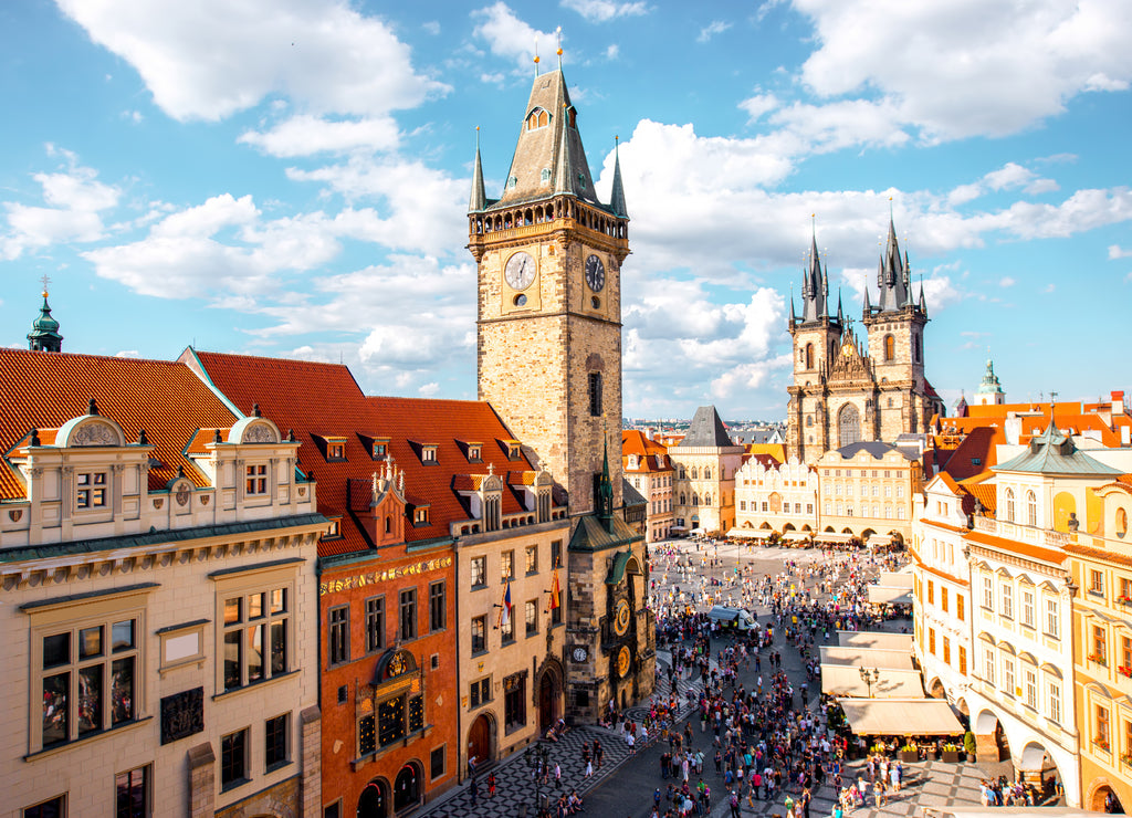 Cityscape view on the clock tower and Tyn cathedral on the old square in Prague