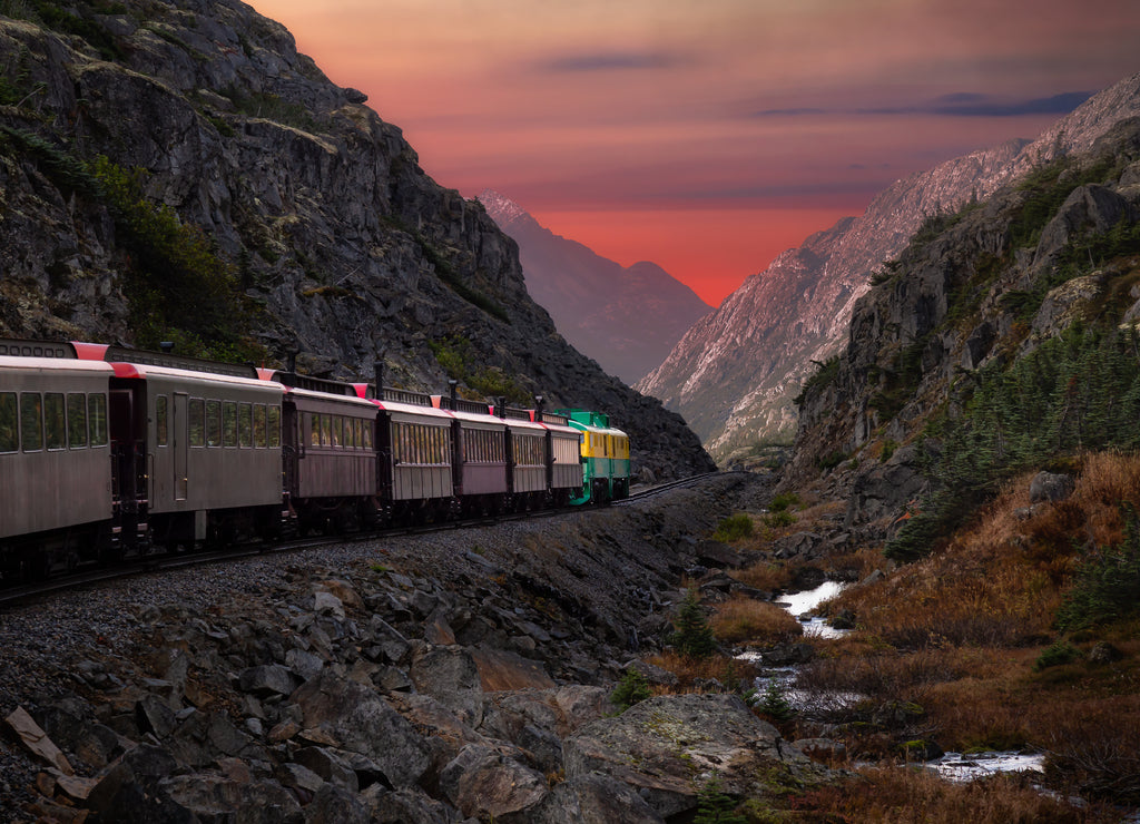 Old Historic Railroad Train is going over White Pass. Moody Colorful Sky Composite. Skagway, Alaska, United States