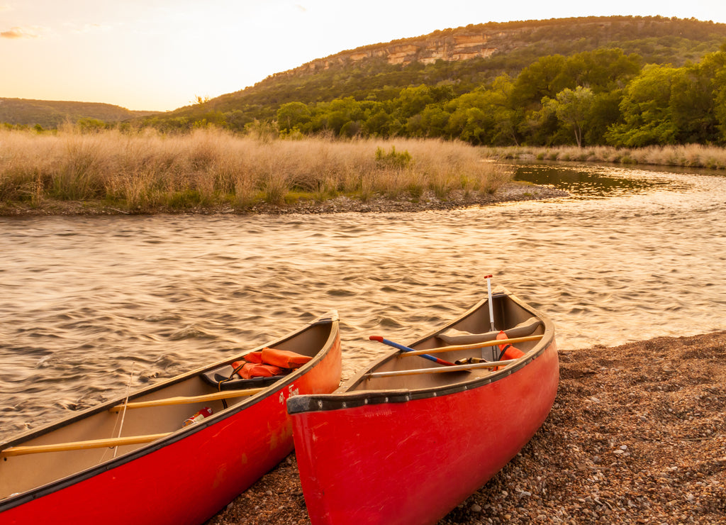 Red Canoes Beside The Brazos River at Sunset, Near Palo Pinto,Texas, USA