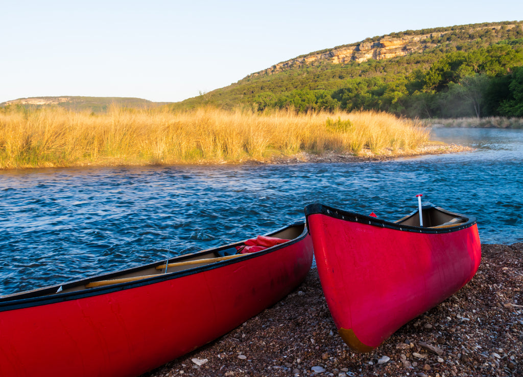 Red Canoes Beside The Brazos River at Sunrise Near Palo Pinto, Texas,USA