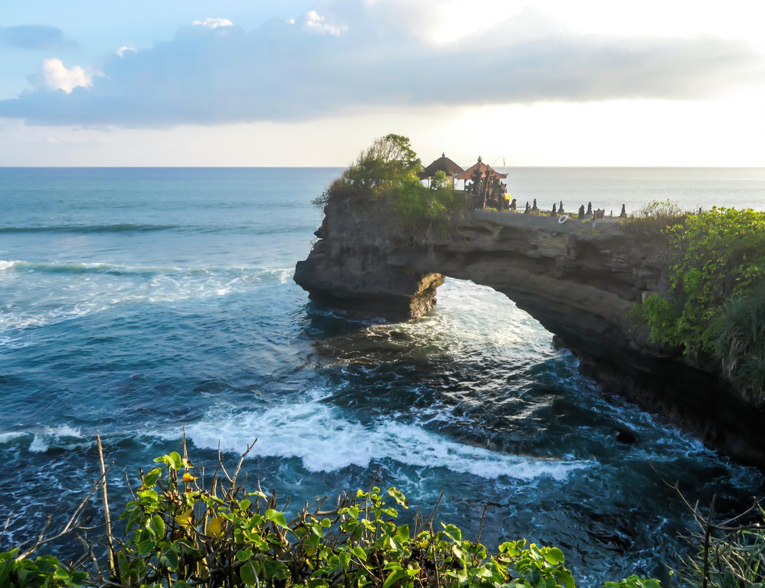 Noah Jigsaw Puzzle Cliffs in the nearby of Tanah Lot Temple, Bali, Indonesia. There is an arch in the water. The waves are splashing on the cliffs and smaller rocks. Water stays on the flat surfaces. Power of the nature 1000 pieces