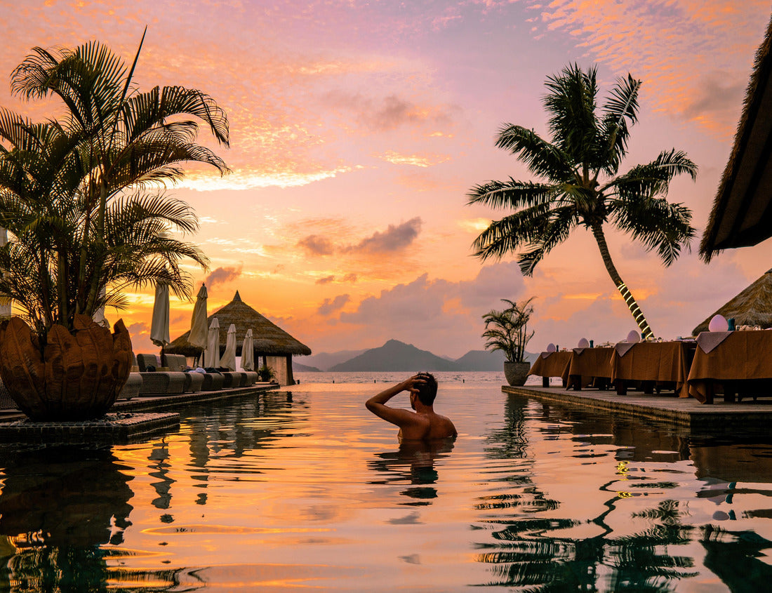 Noah Jigsaw Puzzle Luxury swimming pool in tropical resort, relaxing holidays in Seychelles islands. La Digue, Young man during sunset by swimpool Seychelles 1000 pieces