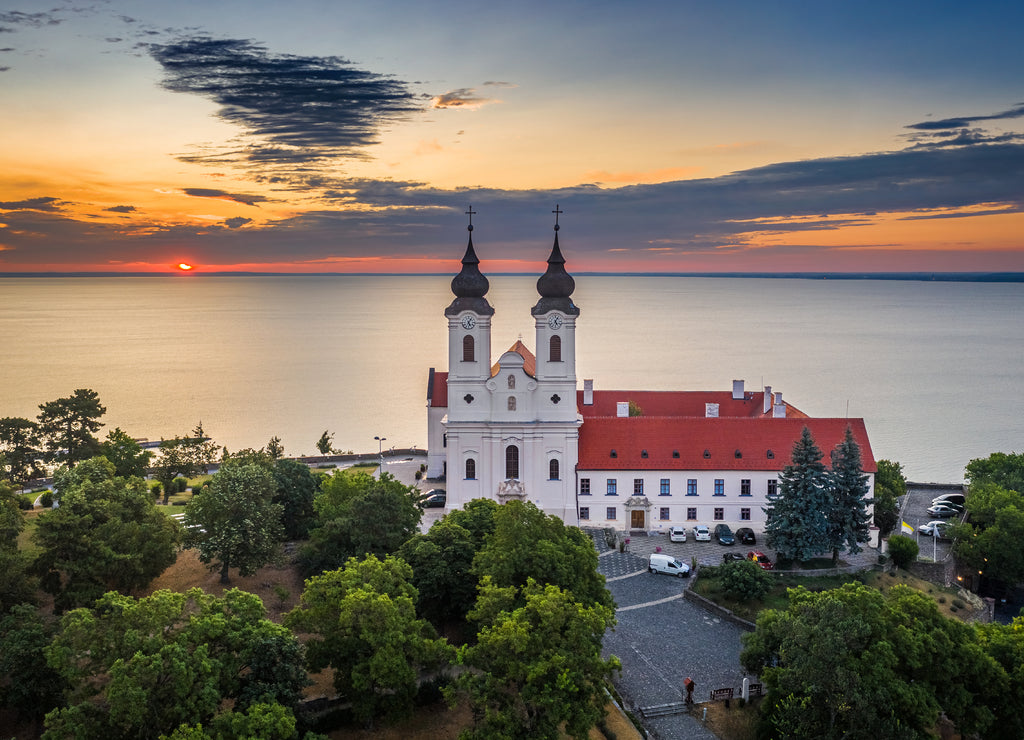 Tihany, Hungary - Aerial skyline view of the famous Benedictine Monastery of Tihany (Tihany Abbey) with beautiful colourful sky and clouds at sunrise over Lake Balaton