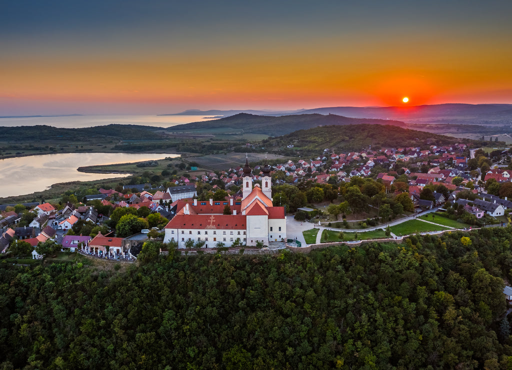 Tihany, Hungary - Aerial panoramic view of the famous Benedictine Monastery of Tihany (Tihany Abbey, Tihanyi Apatsag) with beautiful golden sky at sunset over Lake Balaton on a summer afternoon