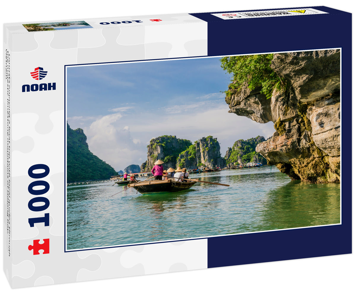 Tourists enjoying a boat trip with local guides through the majestic limestone mountains of Halong bay, Vietnam