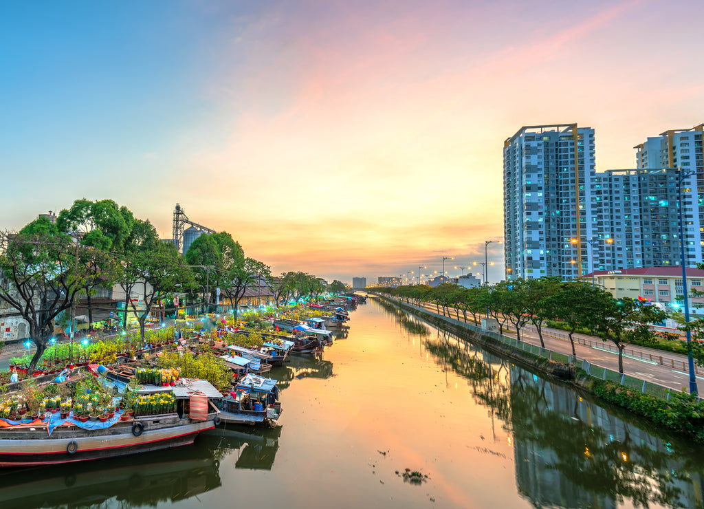 Flower boats full of flowers parked along canal wharf in sunset, a place for bustling flower market trade lunar new year in Ho Chi Minh City, Vietnam
