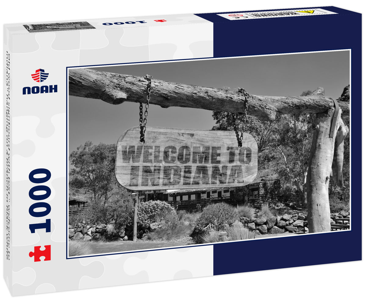 Old wood signboard with text " welcome to indiana" hanging on a branch in black white
