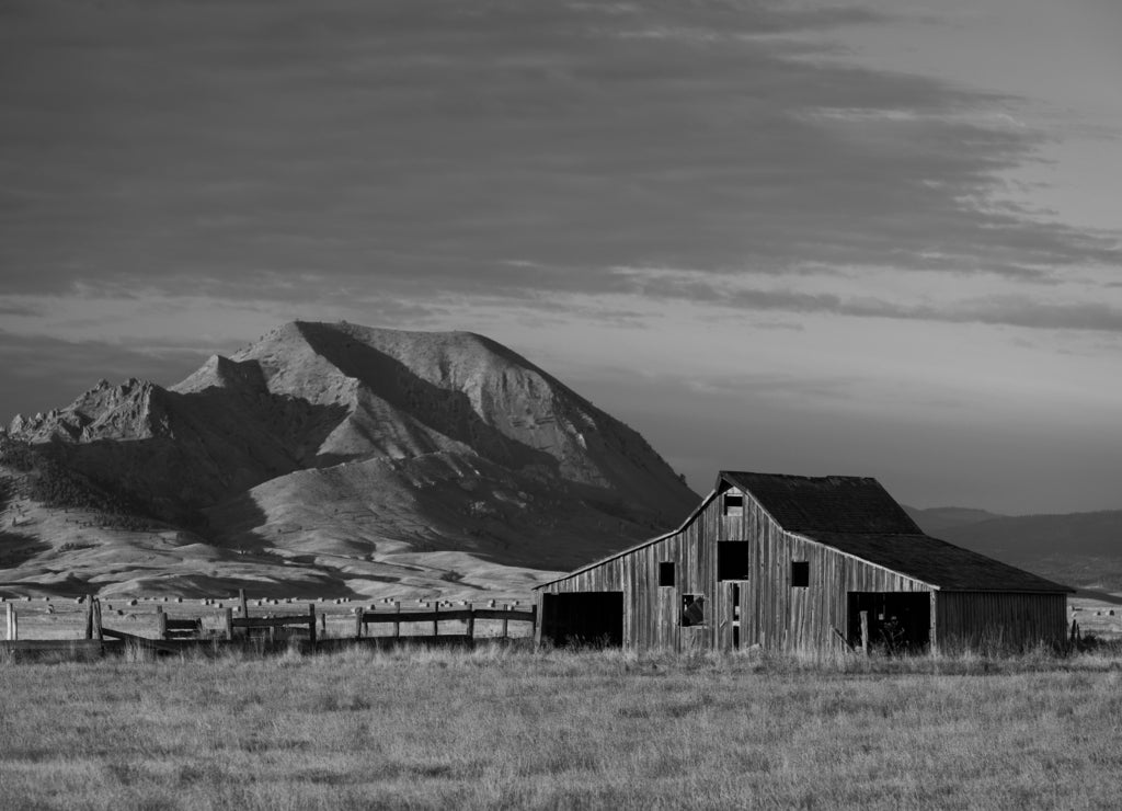 Old barn in front of Bear Butte from Nine Mile Road near Sturgis, South Dakota in black white
