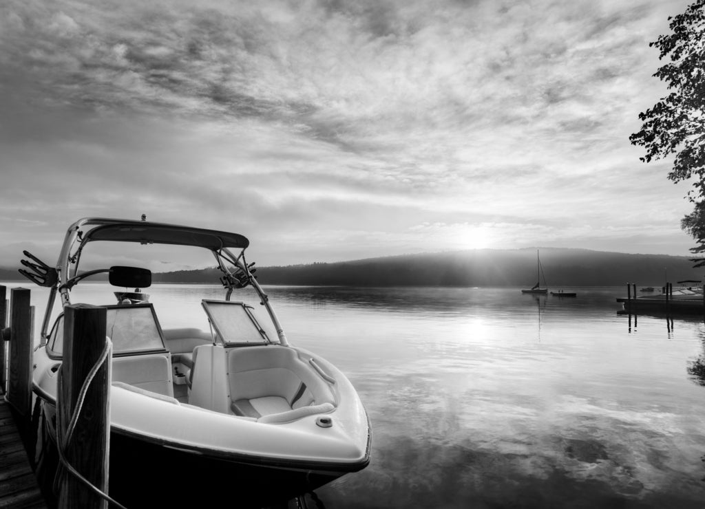 Sun and mist on boat dock at sunrise on a summer day. Merrymeeting Lake, New Hampshire in black white