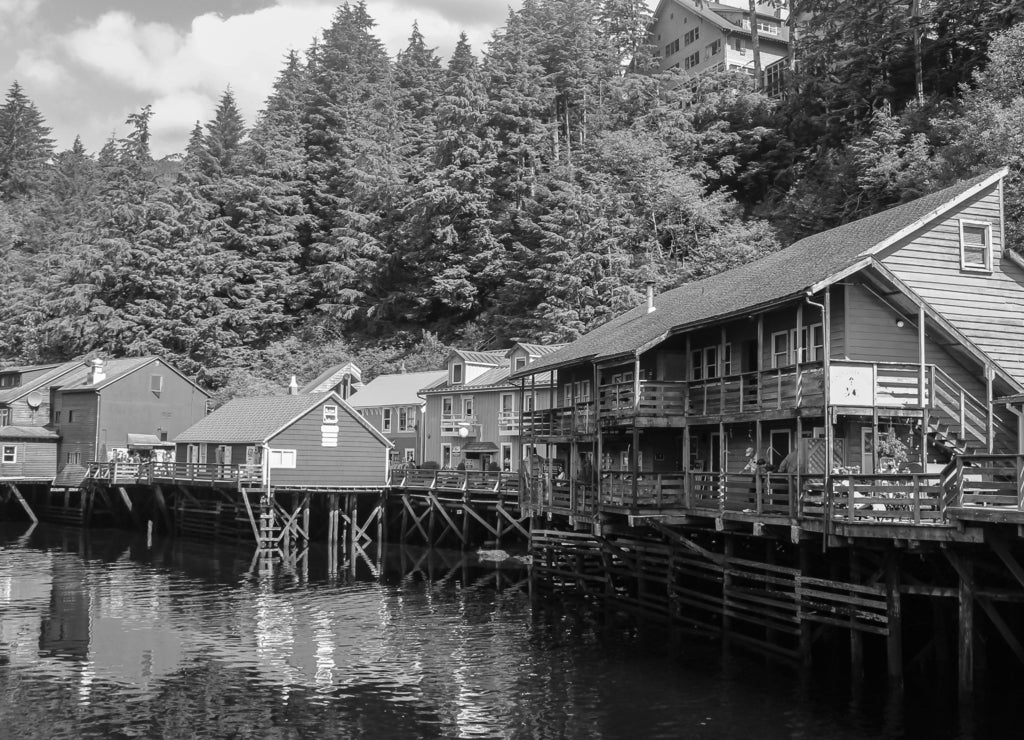 Suspended houses above a small river from Skagway, Alaska in black white