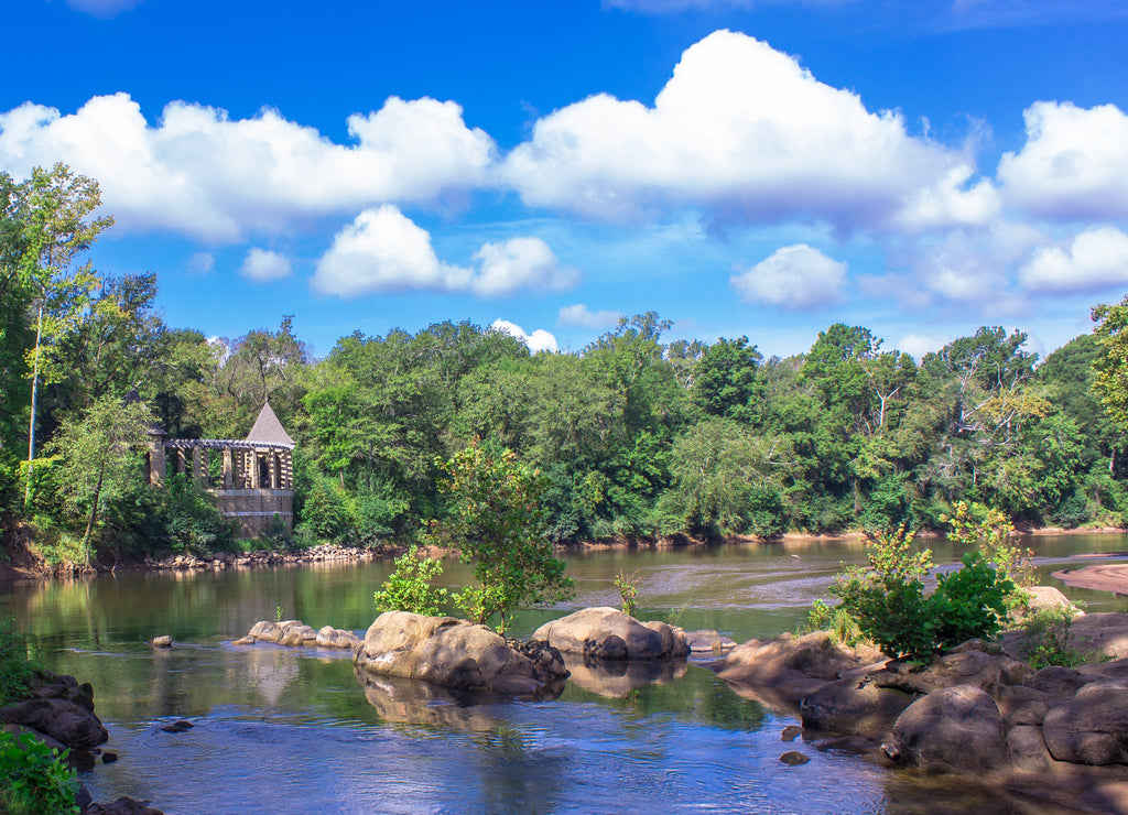 River view of a castle overlook on the Ocmolgee River in Macon, Georgia at Amerson Park with white puffy clouds and blue sky