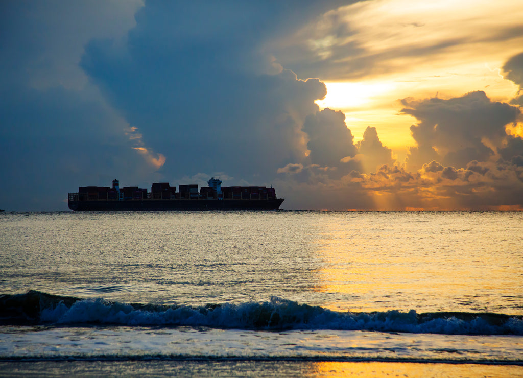 USA, Georgia, Tybee Island. Ship off shore in storm at sunrise