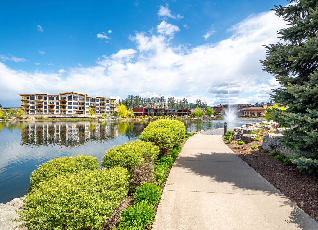 Riverstone public park in Coeur d'Alene, Idaho, USA, with restaurants, new construction and the water fountain spraying in the small lake