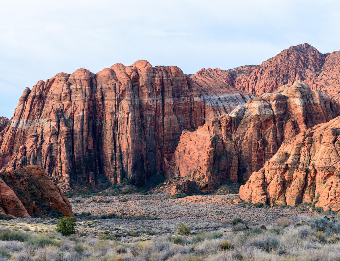 The towering red Navajo sandstone cliffs at Snow Canyon State Park. The breathtaking rock formations rise steeply from the grassy valley below. Taken in the early morning light - St George, Utah, USA 1000pc Puzzle