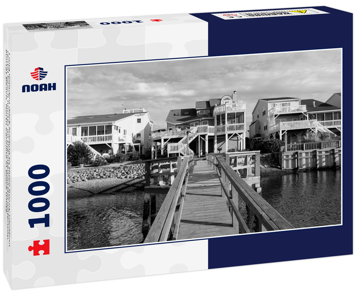 Long wooden dock leading to three luxury vacation rental beach houses on the intercoastal waterway, Sunset Beach, North Carolina in black white