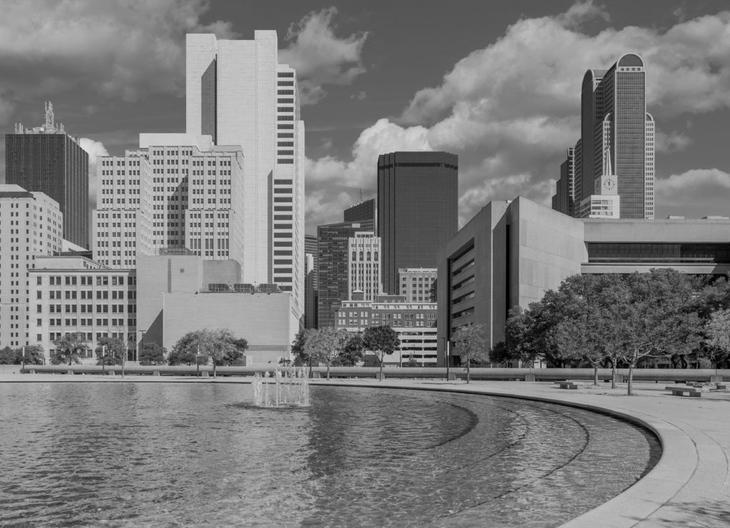 Downtown Dallas buildings line a refreshing fountain courtyard rest area, Texas in black white