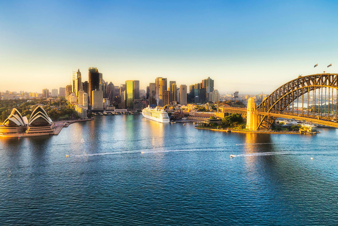 Arch of the Sydney Harbour bridge across Sydney harbour to The Rocks and Circular quay waterfront of city CBD lit by soft morning light between blue waters and sky 2000pc Puzzle