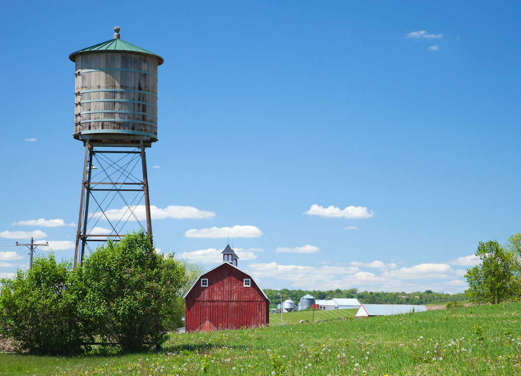Old water cistern and red barn on a bright afternoon, rural Iowa USA