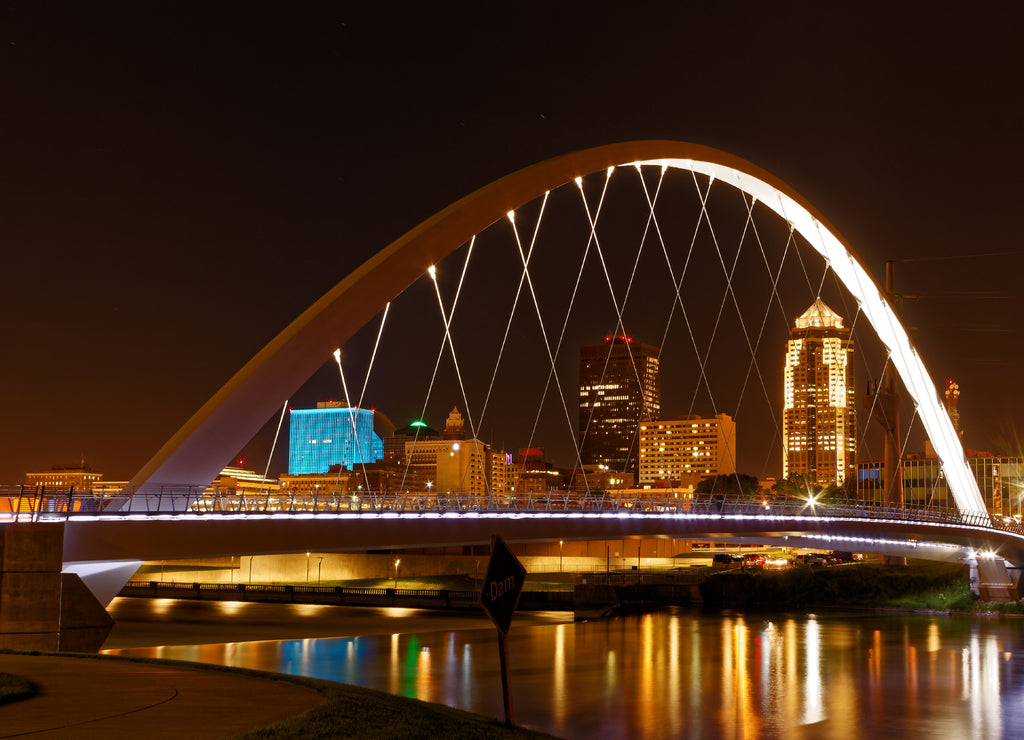 Women of Achievement Bridge that spans the Des Moines River - one of the central features of Des Moines, the skyline of Des Moines is clearly visible through the lit arch, Iowa USA