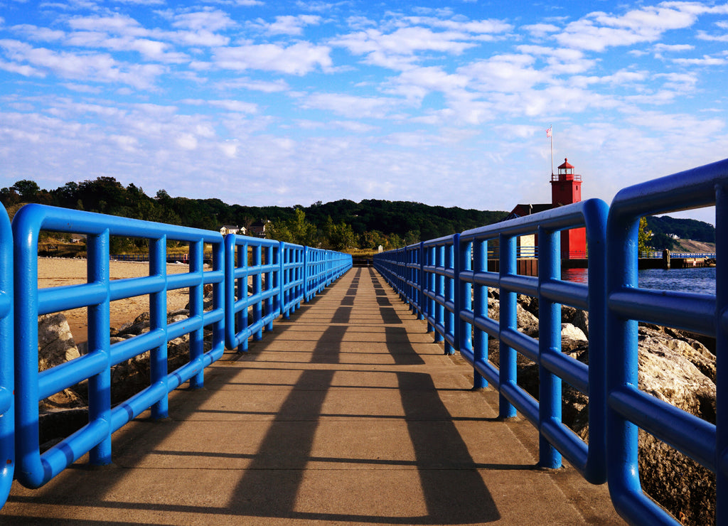 Pier with a bright blue fence in perspective. Big Red Lighthouse. Michigan, Ottawa County