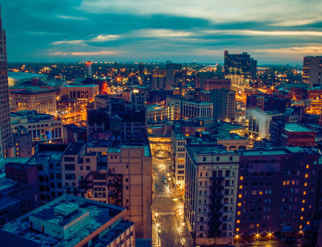 Noah Jigsaw Puzzle Cityscape of Detroit Michigan glowing at sunrise. Historic architecture, commercial buildings, apartments, skyscrapers and other structures in the foreground. Cloudy blue gray sky with hints of orange 1000 Pieces