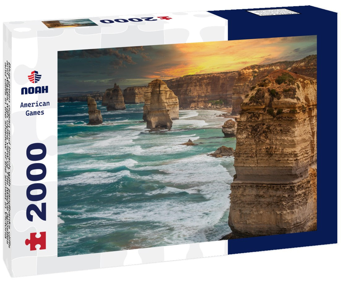 Blue green ocean and beach with sandbanks cliffs and waves with close view of The twelve apostles and cliffs in the shadow of the sunset in Victoria, Australia against a orange cloudy sky 2000pc Puzzle