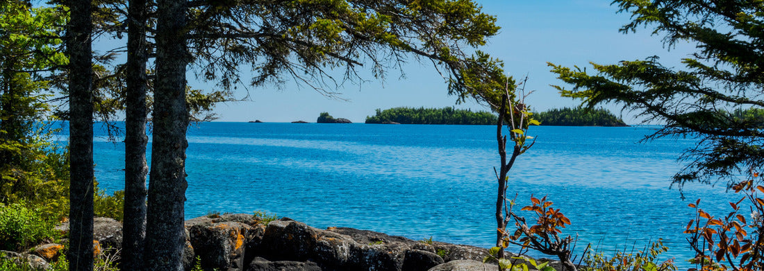 Noah Jigsaw Puzzle A view through the forest shows several of the tiny islands off the main island of Isle Royale NP in Lake Superior off Copper Harbor, MI. Large boulders surround a little water pool on shoreline panorama 1000 pieces