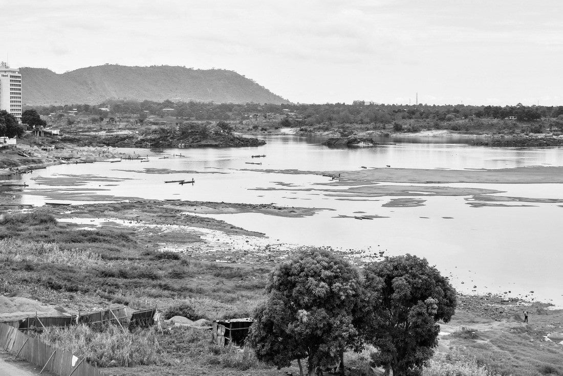 Noah Jigsaw Puzzle View of the Oubangui River in Bangui, Central African Republic, during the dry season, with boats, fishermen, sand-gathering laborers, and buildings on the banks of the river in black white 2000 pieces