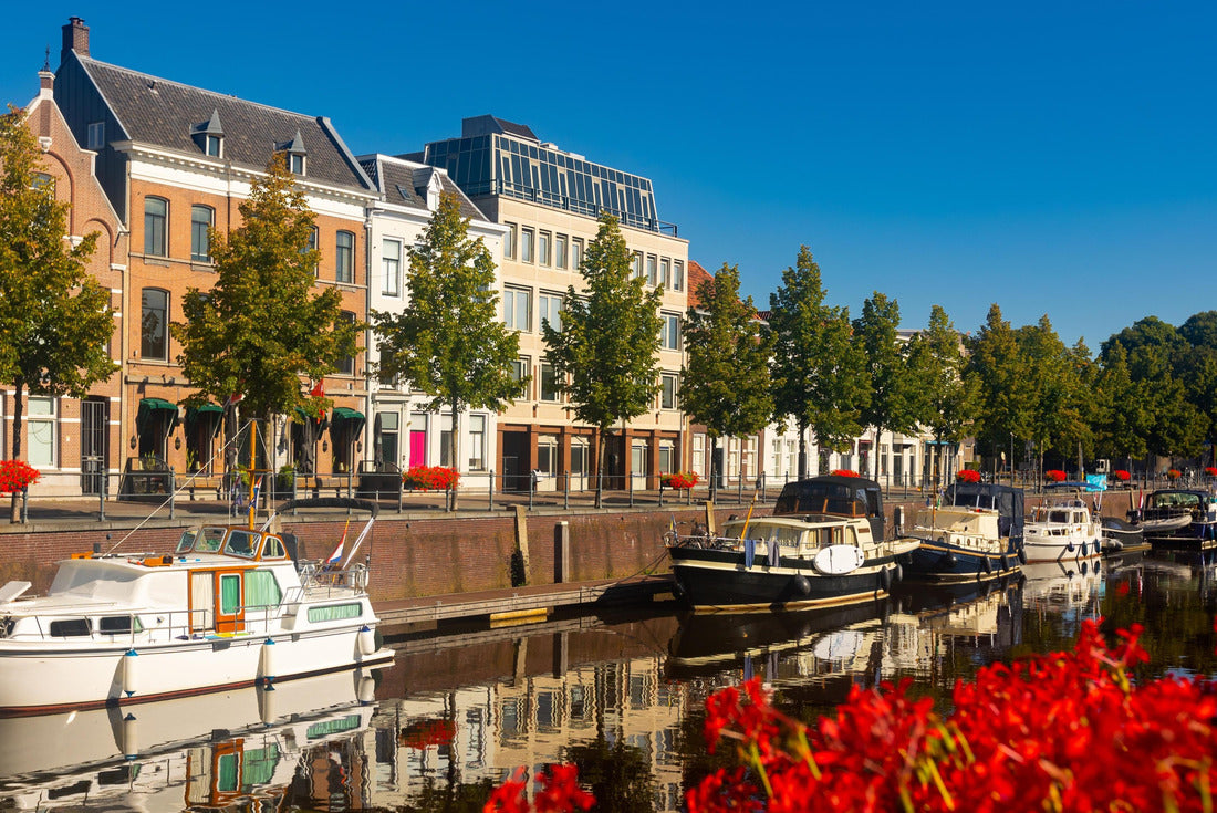 Mark River dam in Breda, Netherlands. View of red flowers in bloom, buildings and boats along the river banks 2000pc Puzzle