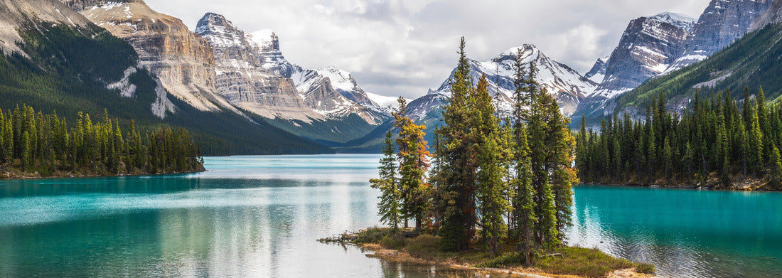 The famous Spirit Island Maligne Lake in Jasper National Park, Alberta, Canada. Vivid blue-green waters of the glacier-filled lake glisten in the sun around the famous pine gathering 1000pc Panoramic Puzzle