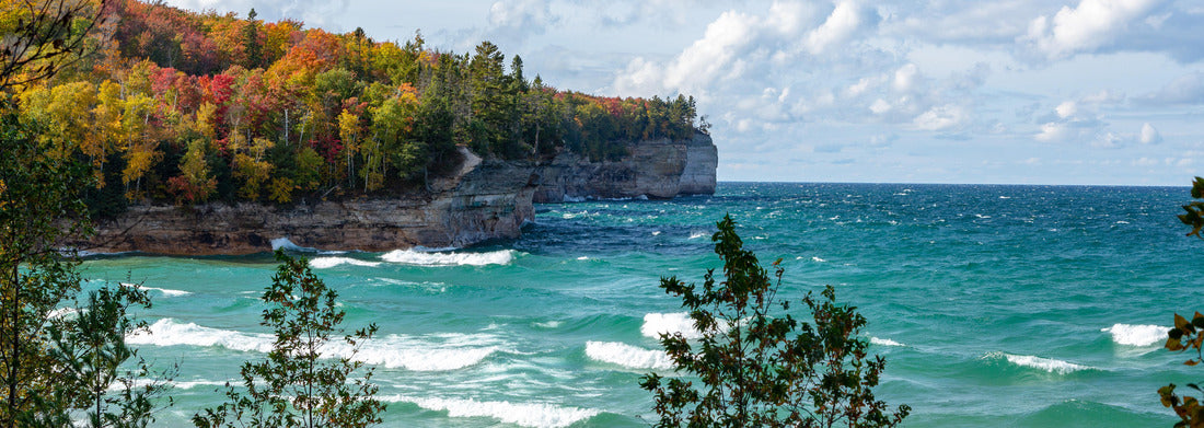 Noah Jigsaw Puzzle A forest on the Upper Peninsula creates an autumn backdrop at Chapel Beach in northern Michigan. Lake Superior crashes onto the beach, puffing clouds of white across the blue sky panorama 1000 pieces