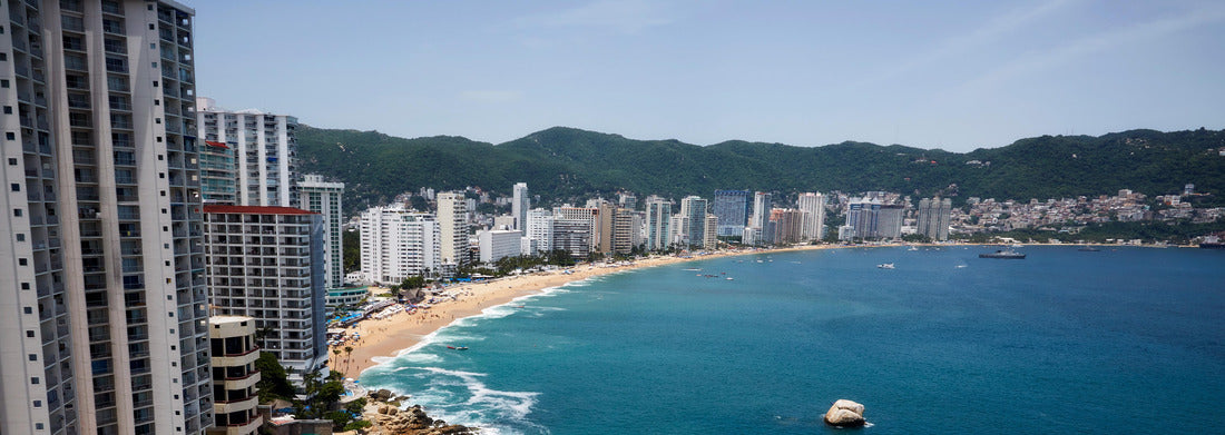 Noah Jigsaw Puzzle Acapulco Bay with its characteristic hotel line in front of a small beach with a beautiful blue ocean on a sunny summer day panorama 1000 pieces