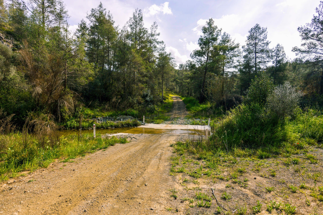 Noah Jigsaw Puzzle A dirt road crosses the river Vathy Argaki Through a ford and climbs a hill surrounded by rocks, green bushes and pine forest and under a blue cloudy sky (Kornos, Larnaca District, Cyprus) 2000 pieces
