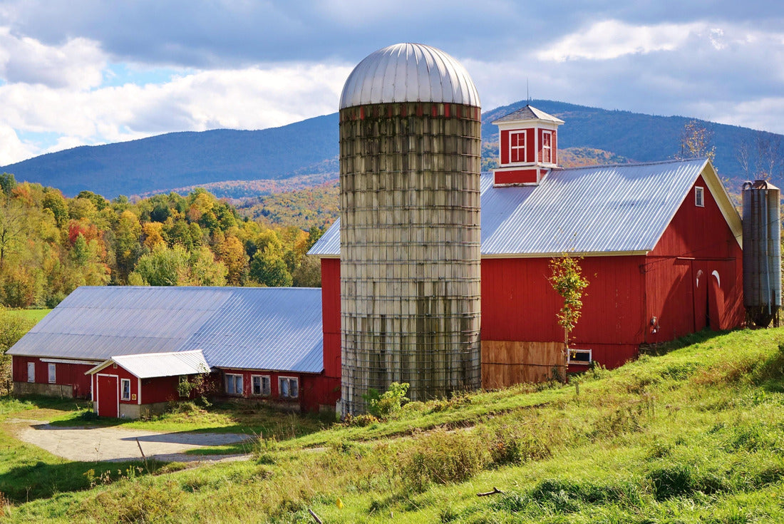 Red barn and silo with a sloping hill and green grass in foreground, trees with fall colors and Vermont mountains in the background under a blue and cloudy sky on a nice autumn day 2000pc Puzzle