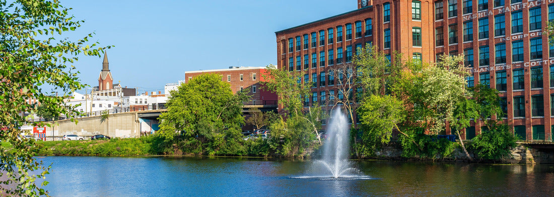 Noah Jigsaw Puzzle Fountain on the Nashua River against the background of a historic cotton factory building with a clock tower in the old industrial park of Nashua. New Hampshire, USA panorama 1000 pieces