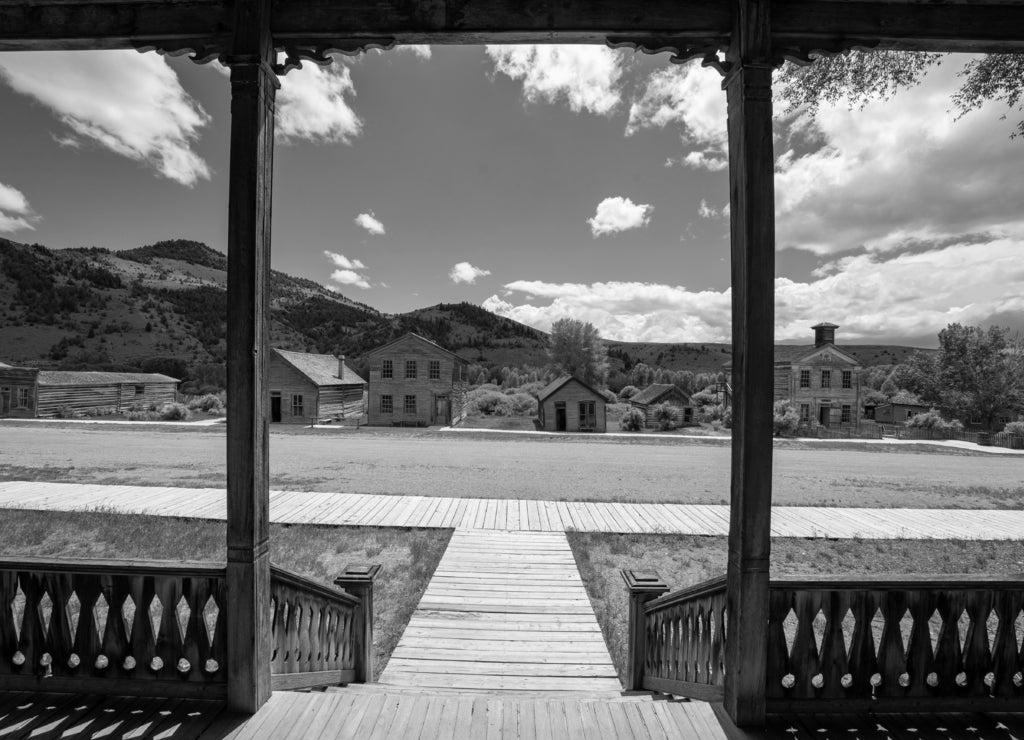 Scenic view from the hotel porch of the other abandoned, decaying buildings of Bannack Ghost Town in Montana in black white