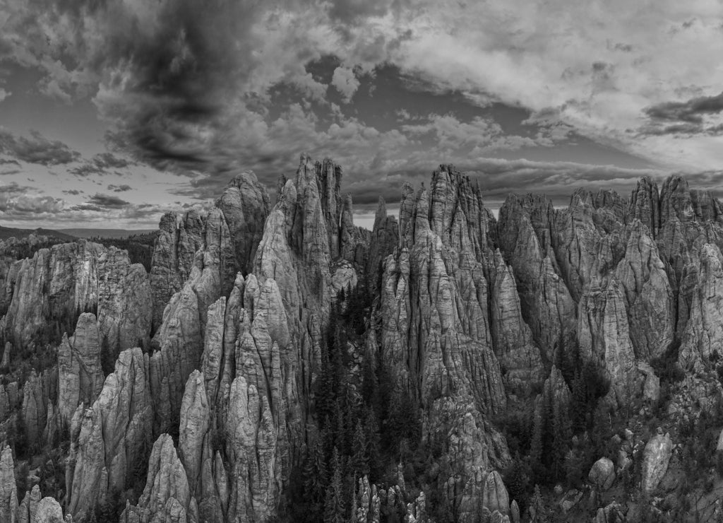 panorama of needles spires with storm clouds in the background off needles highway in black hills of South Dakota in black white
