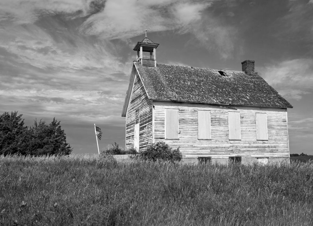 Old white barn majestically sitting on top of a hill against blue sky near Fargo North Dakota in black white